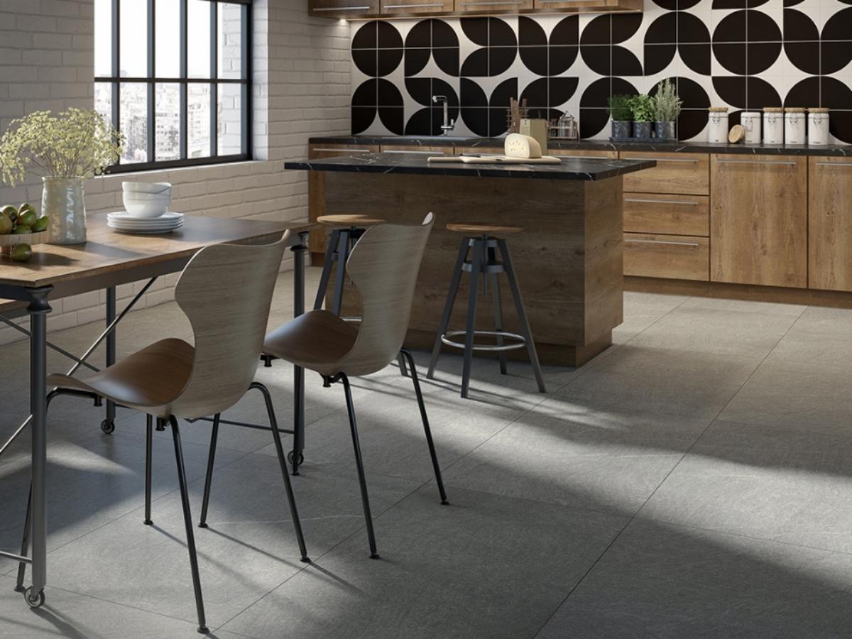 Cocina moderna con piso de losetas grises grandes y un llamativo salpicadero geométrico en blanco y negro